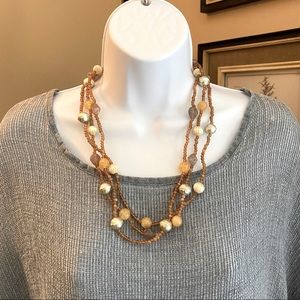 Multi strand beaded necklace with gold tones, tan, ivory taupe and silver. 24”
